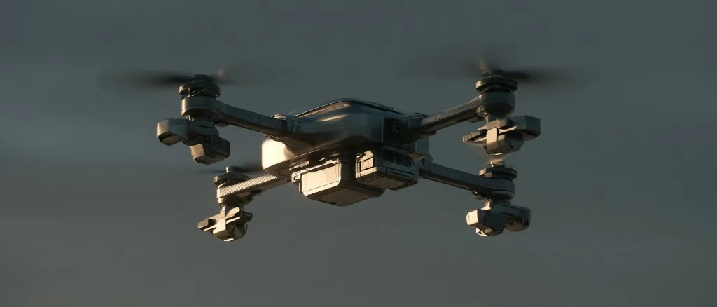 A quadcopter drone hovering against an overcast sky, its four rotors blurred in motion.